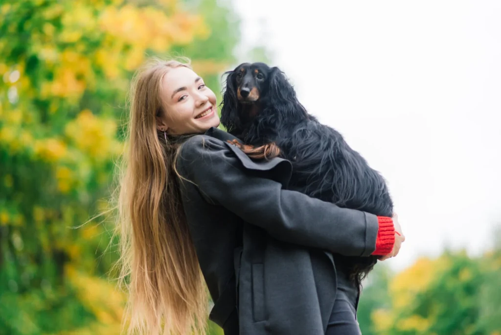 young attractive woman holding her dachshund dog her arms outdoors sunrise park autumn time