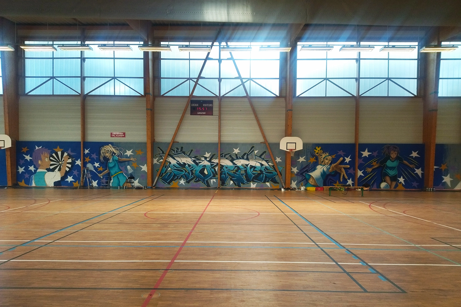 fresque murale dans la salle représentant des sportifs en action 